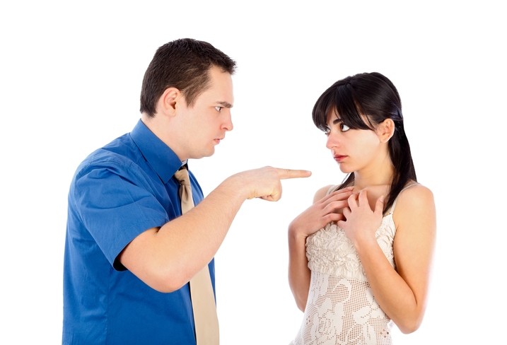 angry man points finger of blame at puzzled woman